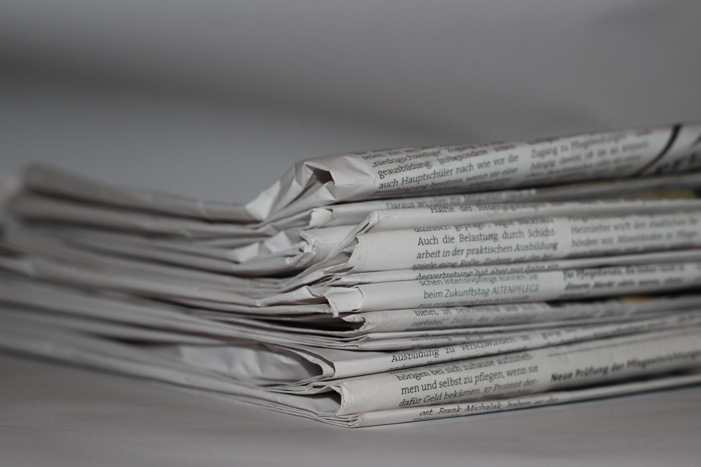 A stack of folded newspapers on a desk
