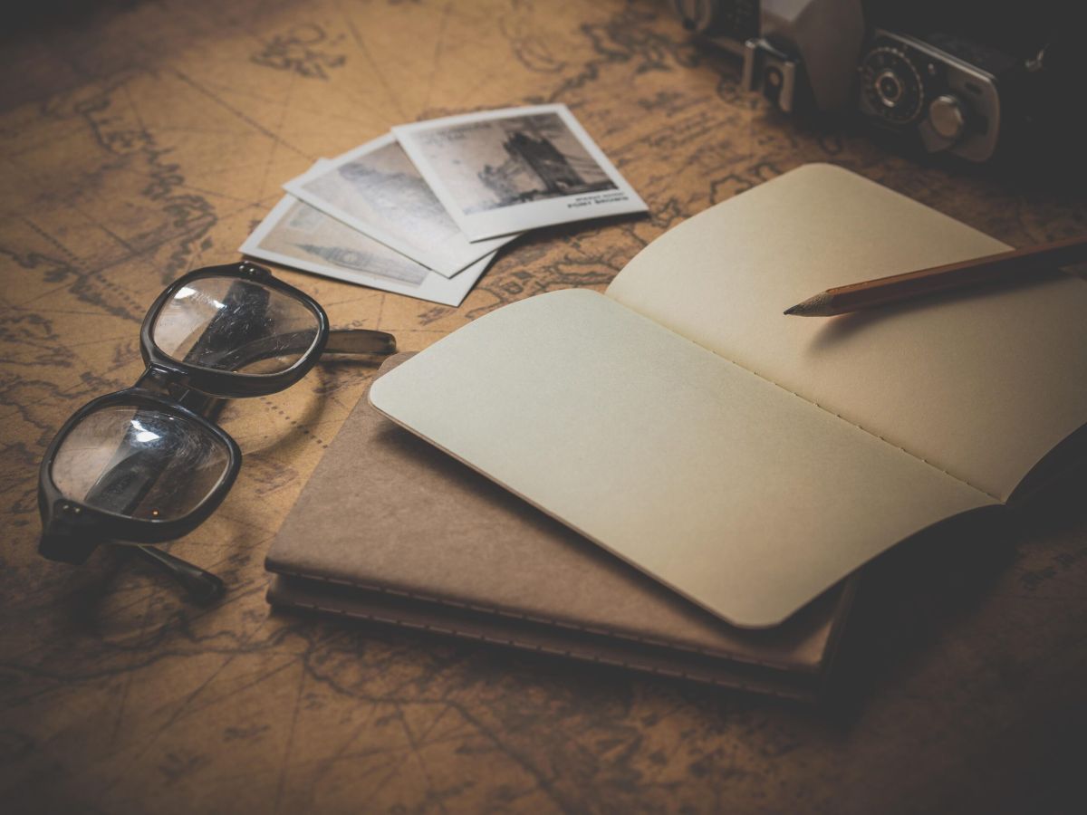 A notepad, spectacles and photographs on a writing desk