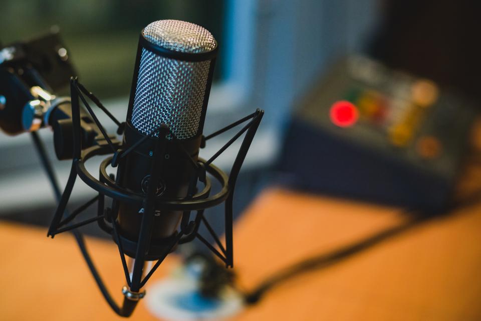 A studio microphone in a broadcast booth, representing the Trust's workshops and mentorship