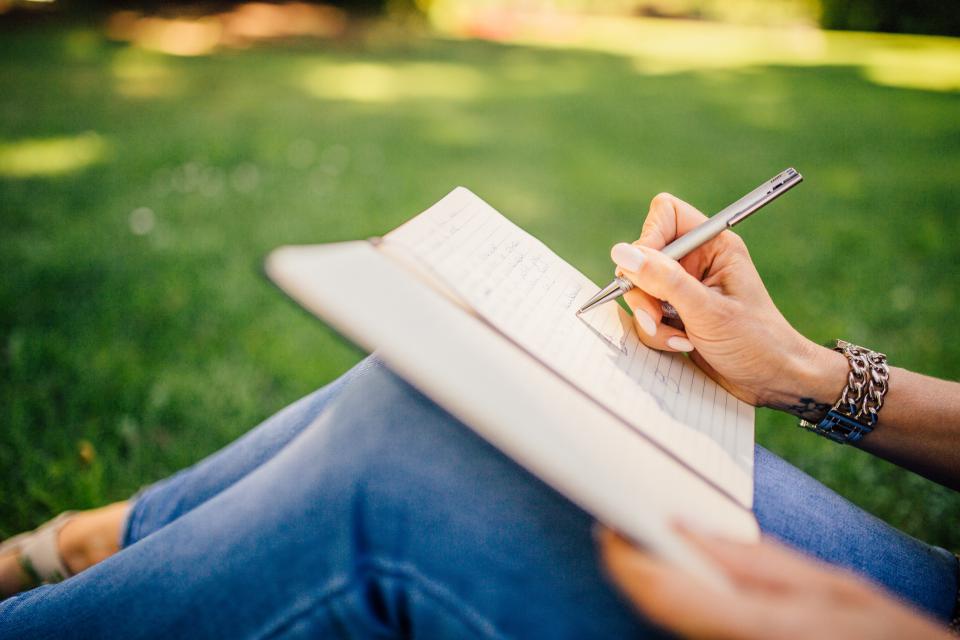 A student writing by hand in an open notebook, representing the Trust's scholarships